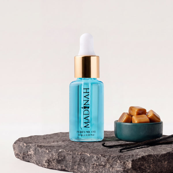 Sweet Caramel Parfümöl, 10-ml-Flakon mit Pipette und hellblauer Füllung auf dunkler Steinplatte, daneben eine Petrol-Schale mit Karamellbonbons und Vanilleschoten
