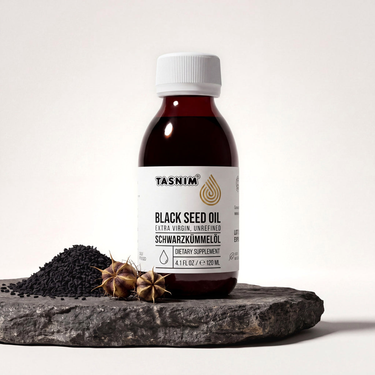 Tasnim Äthiopisches Schwarzkümmelöl, Flasche auf Basaltplatte mit Petrol-Schale voller Schwarzkümmelsamen