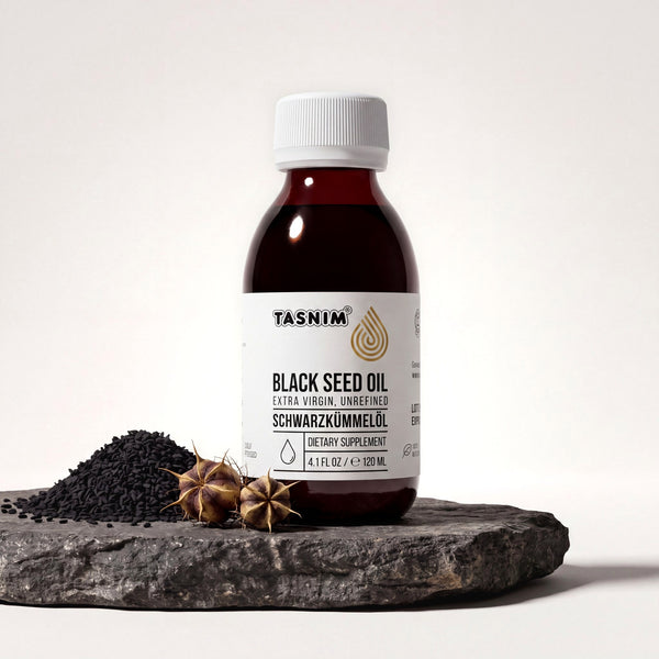 Tasnim Äthiopisches Schwarzkümmelöl, Flasche auf Basaltplatte mit Petrol-Schale voller Schwarzkümmelsamen
