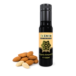 Flasche Tasnim Bio Mandelöl 100 ml neben ganzen und geschälten Mandeln auf weißem Hintergrund