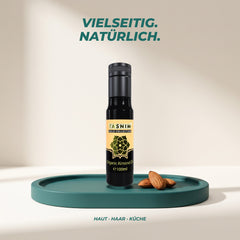 Vielseitig und natürlich: Mandelöl für Haut, Haar und Küche auf einem Petrol-Podest mit Mandeln