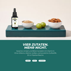 Vier Zutaten: Flasche mit Sesamsamen, Amla-Früchten und Mandeln – Sesamöl, Amlaöl, Bittermandelöl und Vitamin E