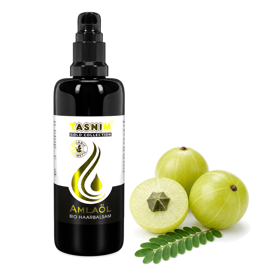 Schwarze 100 ml Flasche Bio Amlaöl Haarbalsam neben frischen Amla-Früchten, der indischen Stachelbeere, auf weißem Hintergrund