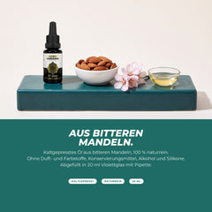 Aus bitteren Mandeln: Flasche mit Mandeln, Mandelblüte und einer Schale Öl – kaltgepresst, naturrein, ohne Zusätze
