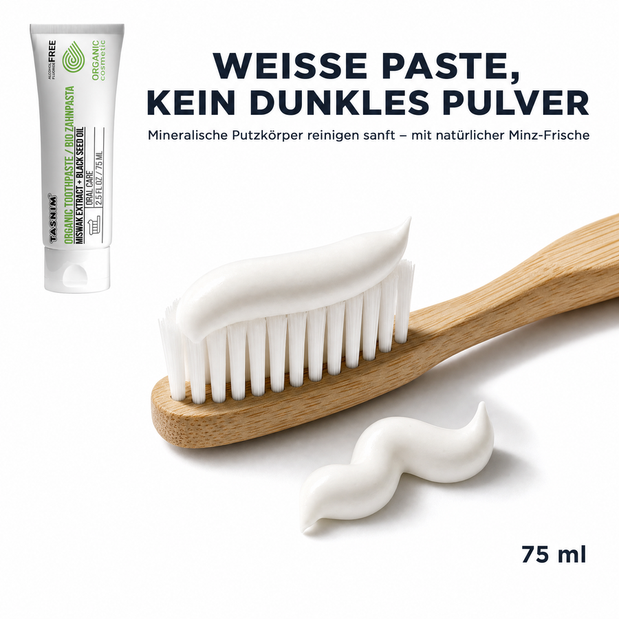 Textur-Makro: weiße Tasnim Bio-Zahnpasta als Strang auf einer Bambus-Zahnbürste und auf weißem Untergrund, daneben die 75-ml-Tube. Text: Weiße Paste, kein dunkles Pulver – mineralische Putzkörper reinigen sanft mit natürlicher Minz-Frische.