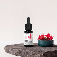 Tasnim Monarda Supercritical CO2 Extract, 30-ml-Pipettenflasche auf Basaltplatte, daneben eine Petrol-Schale mit roten Goldmelissen-Blüten