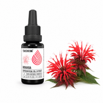 Tasnim Monardaöl 30 ml Flasche neben frischen roten Blüten der Goldmelisse (Monarda didyma)