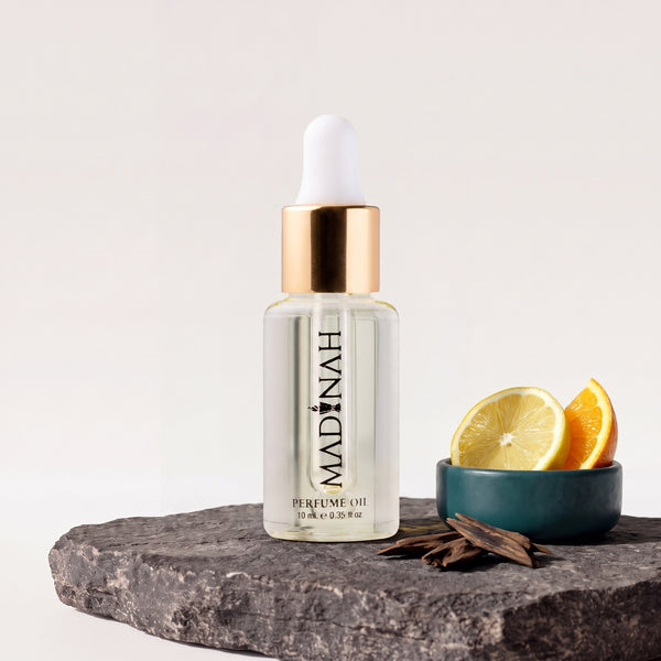 Citrus Orient Parfümöl, 10-ml-Flakon mit Pipette und klarer Füllung auf dunkler Steinplatte, daneben eine Petrol-Schale mit Zitronen- und Orangenscheiben